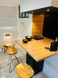 a kitchen with a wooden counter and two stools at Feel@Home Nemausus « Le 42 » in Nîmes