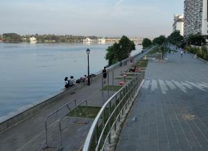 a group of people sitting on a sidewalk next to a river at Astro Marine Hospitality Pvt Ltd in Cochin