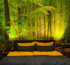 a bedroom with a forest mural on the wall at Wood-Appartement in Bielefeld
