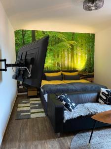 ein Wohnzimmer mit 2 Betten und einem großen TV in der Unterkunft Wood-Appartement in Bielefeld