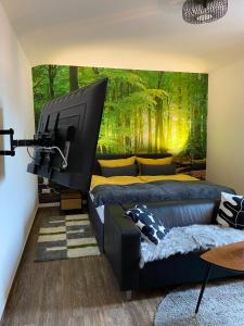 a living room with two beds and a large television at Wood-Appartement in Bielefeld
