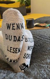 ein Handtuch mit den Worten: "Heißer Dave brennt Lesben auf einem Bett." in der Unterkunft Wood-Appartement in Bielefeld