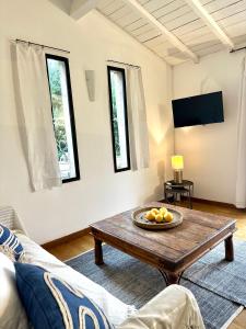 een woonkamer met een tafel en een bank bij CASA AZUL - jardin, calme, tennis in Nîmes