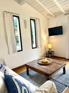 uma sala de estar com uma mesa e um sofá em CASA AZUL - jardin, calme, tennis em Nîmes
