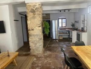 a kitchen and dining room with a stone pillar at Casa Lucas in Grazalema