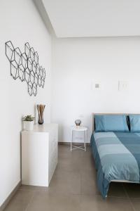 a white bedroom with a blue bed and a white cabinet at A CASA DI FIBI in Salerno