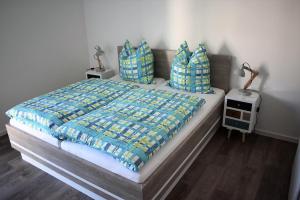 a bedroom with a large bed with blue pillows at 50 3 N Nordkoje in Wangerland