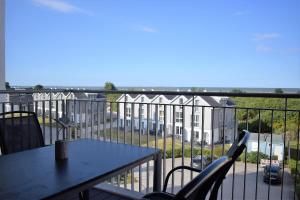 a balcony with a table and chairs and a building at 50 3 N Nordkoje in Wangerland