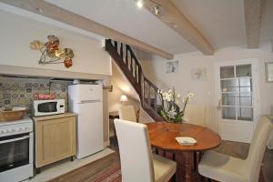 a kitchen and dining room with a table and a microwave at La maison de marie in Saint-Germain-les-Belles