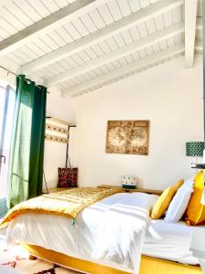 una camera da letto con un grande letto con cuscini gialli di villa Luberon a Saint-Saturnin-lès-Apt