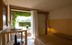 a bedroom with a bed and a desk and a window at Hotel Villa Ca' Sette in Bassano del Grappa