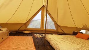 a tent with a bed and a large window at Sublim' Ecolodge in Abela