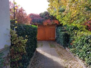 einen Garten mit einem Holzzaun und einem Holztor in der Unterkunft Ferienwohnung Heil - Königs Wusterhausen in Königs Wusterhausen