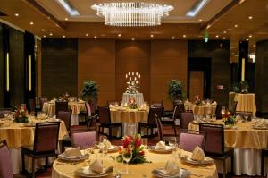 um salão de banquetes com mesas e cadeiras e um lustre em Vivanta Hyderabad, Begumpet em Hyderabad