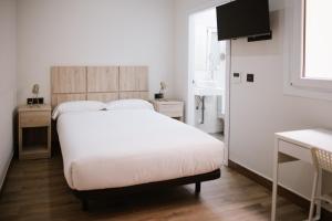 1 dormitorio con cama blanca y lavamanos en Melilla Centro Hotel ***, en Melilla