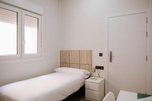 1 dormitorio con 2 camas y ventana en Melilla Centro Hotel ***, en Melilla