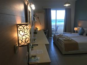 A bed or beds in a room at Bayside Hotel Katsaras