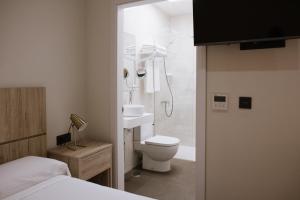 een badkamer met een douche, een toilet en een wastafel bij Melilla Centro Hotel *** in Melilla