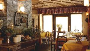a dining room with a table and a stone wall at Hotel Breithorn in Champoluc