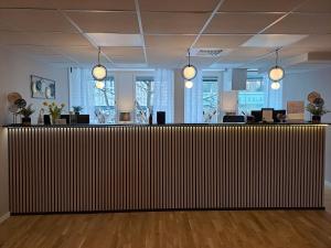 an office with a large wooden reception desk in a room at Hotell Västerås in Västerås