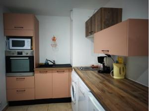 a kitchen with brown cabinets and a counter top at Appartement aux Airelles in Embrun