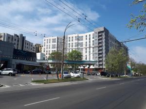 an empty city street with a large white building at Новая, уютная квартира по ул. Grenoble 120/10 in Chişinău