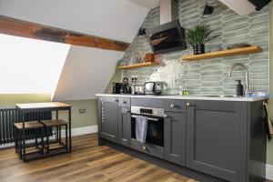 una cocina con armarios grises y electrodomésticos de acero inoxidable en no 12 - Stunning Self Check-in Apartments in Worcester Centre en Worcester