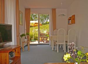 a living room with a table and chairs and a television at Haus Seeschwalbe Ferienwohnungen in Göhren