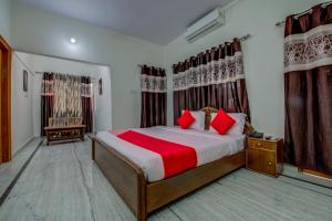 1 dormitorio con 1 cama grande con almohadas rojas en OYO Flagship Corporate Club, en Ranchi