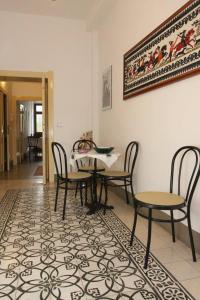 un comedor con mesa y sillas sobre una alfombra en Sa Pruninca en Villanova Monteleone