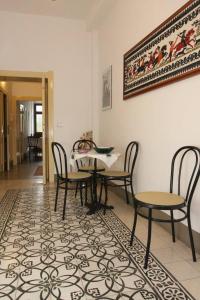 a dining room with a table and chairs on a rug at Sa Pruninca in Villanova Monteleone