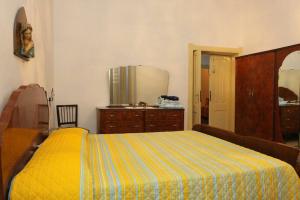 a bedroom with a yellow bed and a dresser at Sa Pruninca in Villanova Monteleone