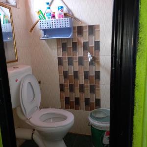 uma casa de banho com um WC e uma lata de lixo em Nur's Homestay em Seri Manjung