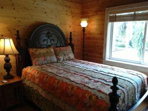 a bedroom with a bed with two lamps and a window at Hana Mana in Yakushima