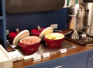 a kitchen with four red pots and pans on a counter at NETIZEN Budapest Centre in Budapest