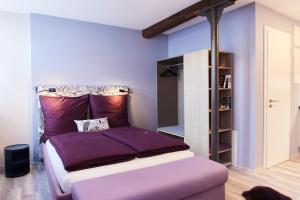 ein Schlafzimmer mit einem Bett mit violetter Bettwäsche in der Unterkunft Fachwerk-Romantik am Dom in Fulda