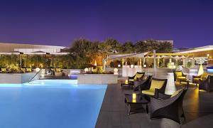 a swimming pool with chairs and tables at night at Dubai Mall Highest Floor With Burj Khalifa View Residence - Formerly Address Dubai Mall in Dubai