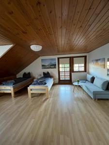 un soggiorno con 2 divani e un soffitto in legno di Ferienwohnung Schneider mit Balkon a Bad Laasphe