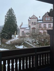una vista dal balcone di una casa nella neve di Ferienwohnung Schneider mit Balkon a Bad Laasphe