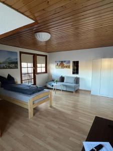 a bedroom with a bed and a couch in a room at Ferienwohnung Schneider mit Balkon in Bad Laasphe