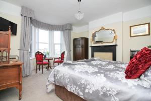 濱海韋斯頓的住宿－The Beach House Luxury Rooms Weston Super Mare，卧室配有一张床和一张桌子及椅子