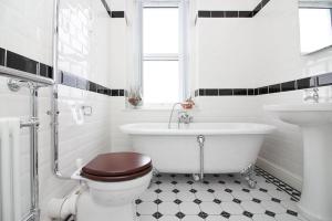 a bathroom with a tub and a toilet and a sink at The Beach House Luxury Rooms Weston Super Mare in Weston-super-Mare