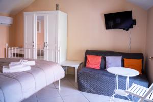 Cette chambre comprend un lit, un canapé et une table. dans l'établissement Agriturismo Casa Scola, à Gragnano