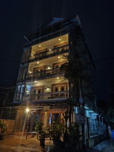 a tall building at night with a building at Beat Hotel Siem Reap in Siem Reap