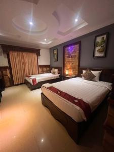 a large bedroom with two beds and a fireplace at Beat Hotel Siem Reap in Siem Reap