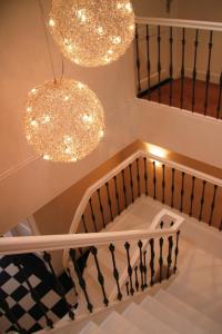 a staircase with two chandeliers and a stair case at Appartementen het Centrum in Domburg