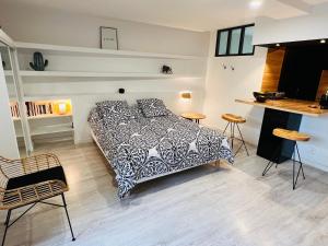 1 dormitorio con 1 cama, mesa y sillas en Feel@Home Nemausus « Le 42 », en Nimes