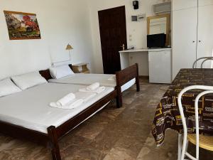 a bedroom with two beds and a kitchen with a tv at Astra House in Paralio Astros