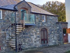 a stone house with a staircase on the side of it at Mount Pleasant Country House in Lucan