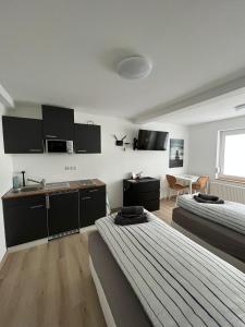 a bedroom with two beds and a kitchen and a table at Ferienappartment & Ferienwohnung Banfetal in Bad Laasphe